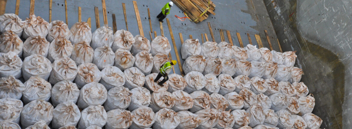 Workers load bagged cargo.